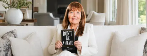 Polly Harder holding Don't Be Afraid